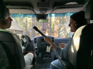Audio producer recording an interview in a sprinter van