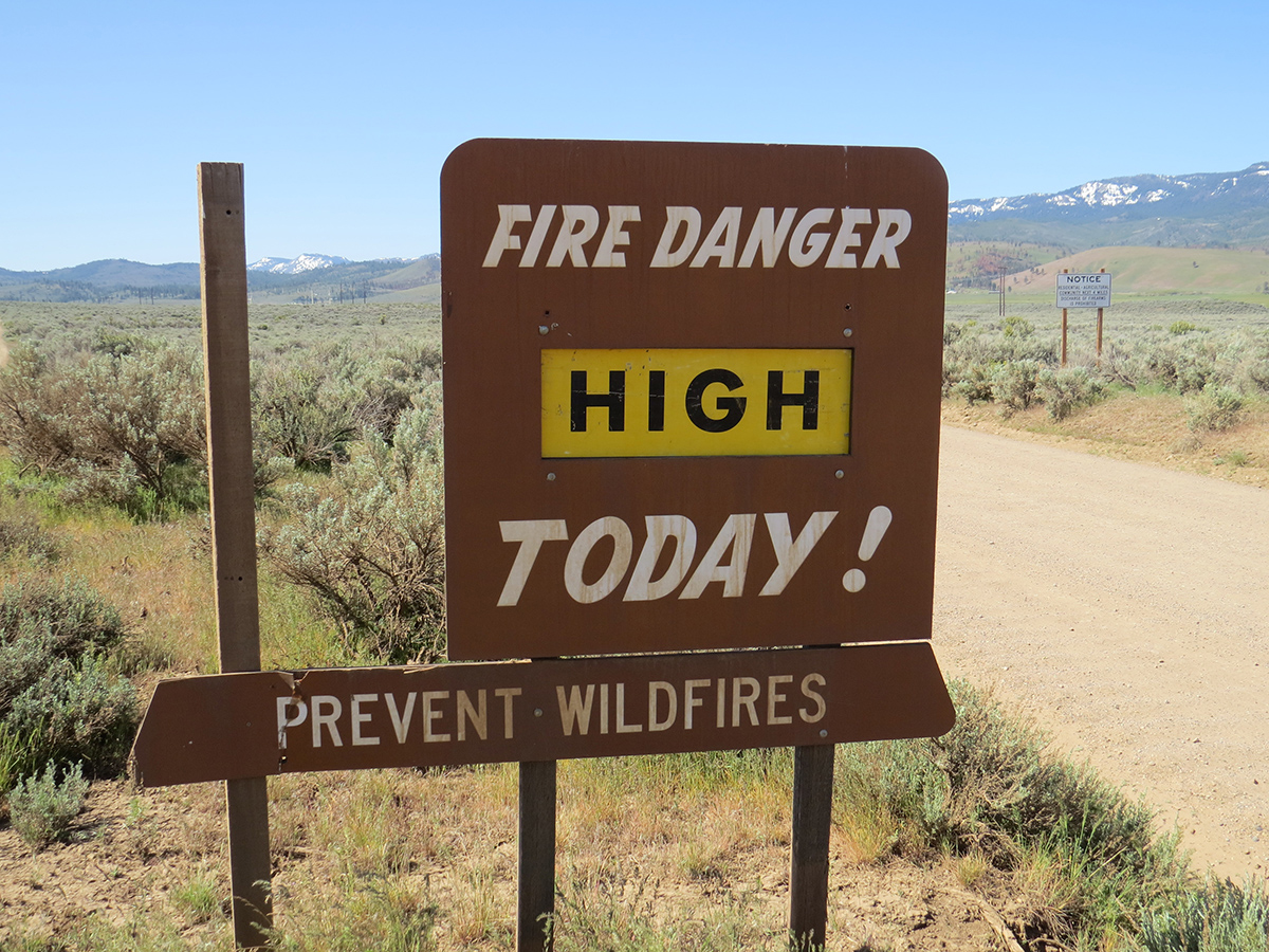 A wooden sign showing high fire danger for the day is located on the way to Prema Farm.